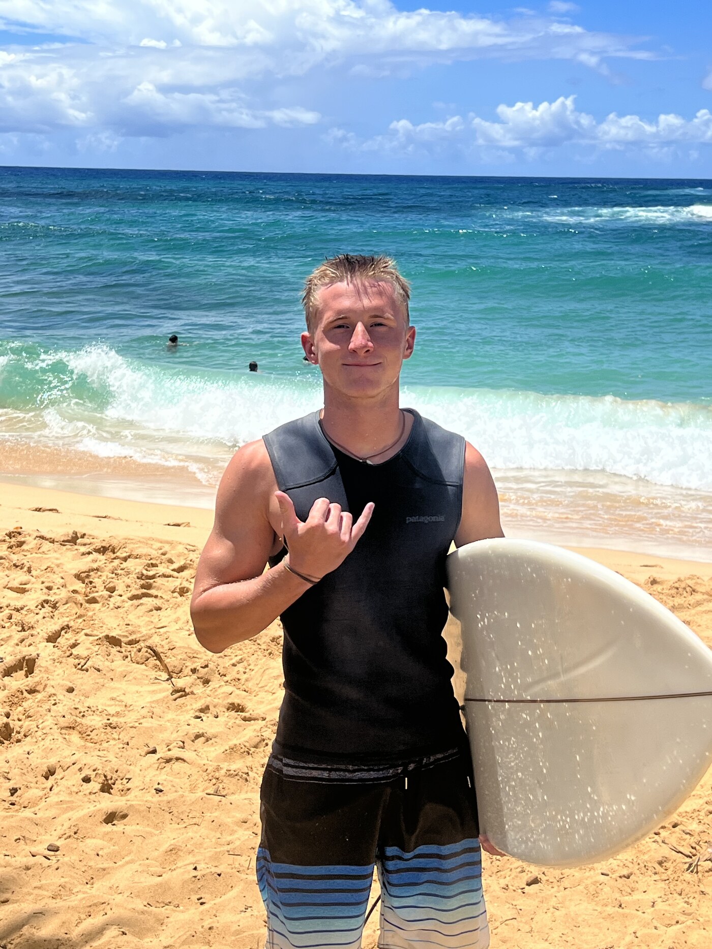 Drake on the beach with a surfboard